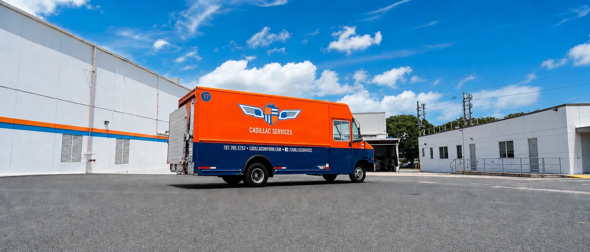 Cadillac Services delivery truck in orange and navy livery